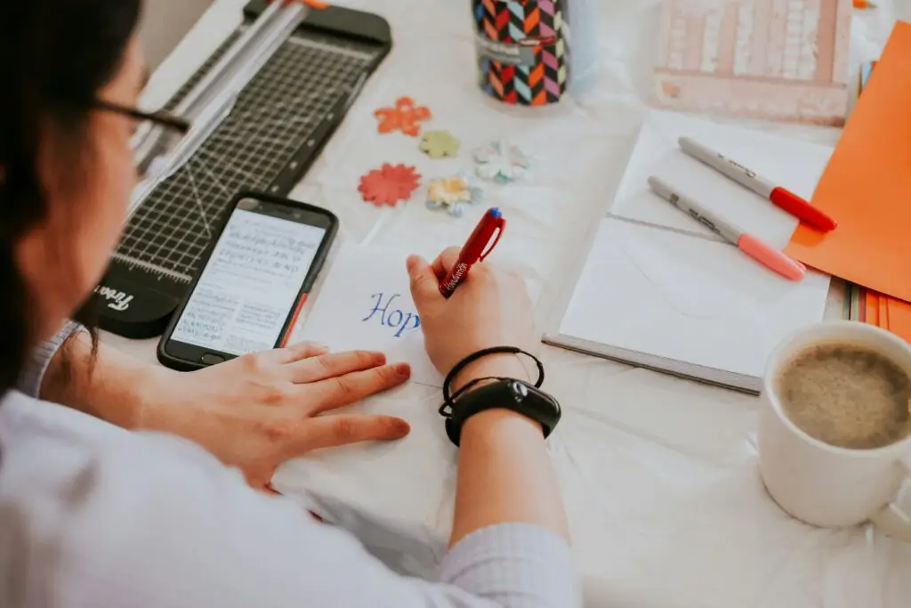 écreire sur un carnet, café, stylo, téléphone